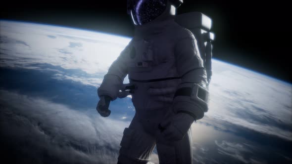 Astronaut in Outer Space Against the Backdrop of the Planet Earth