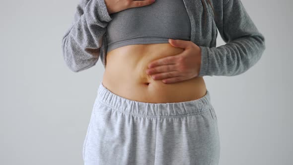 Woman Compressing the Skin on Her Stomach Checking for Cellulite and Excess Subcutaneous Fat