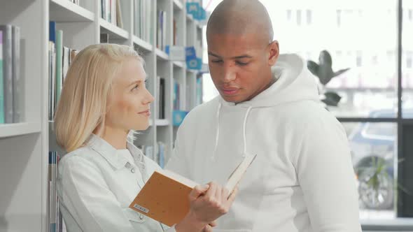 Lovely Couple Reading a Book Together at the Library