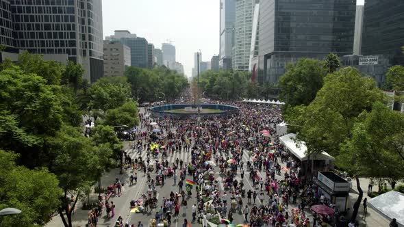 backwards drone shot of the crowd gathered to celebrate the pride parade in mexico city on paseo de