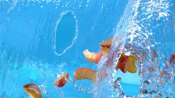 Ripe Peach Fruit Slices Falling Into Water Splash Cascade In Slow Motion 4k