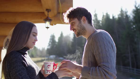 Young girl handing a mug to a young man alt