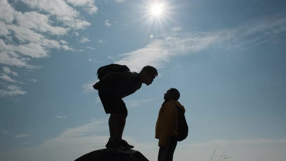 Silhouette of Couple in love kissing on top of the mountain. Love and Travel concept.