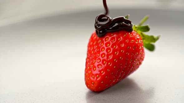 Healthy Seasonal Food. Bright Red Yummy Sweet Strawberry Being Poured with Liquid Chocolate