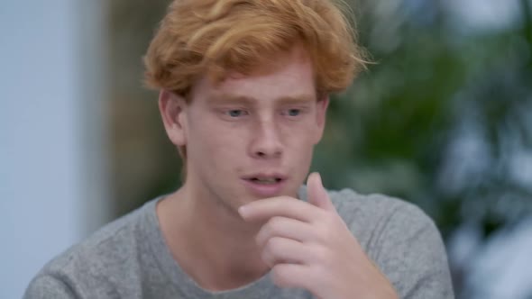 Young Millennial Handsome Redhead Man Talking and Thinking. Close-up Portrait of Confident Caucasian