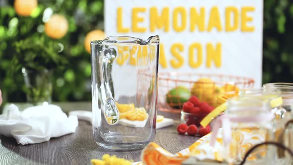 Step by step. Preparing raspberry lemonade with fresh lemons and raspberries in drinking mason jars.