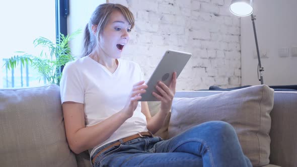 Reaction to Success By Woman Using Tablet in Bedroom