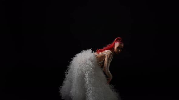 Gorgeous Confident Woman in Stage Costume Dancing at Black Background Looking at Camera