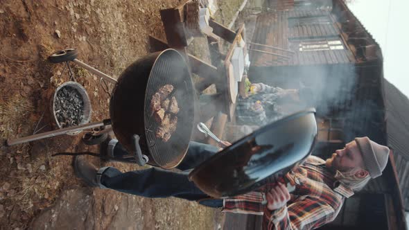 Man Barbecuing Meat Outdoors