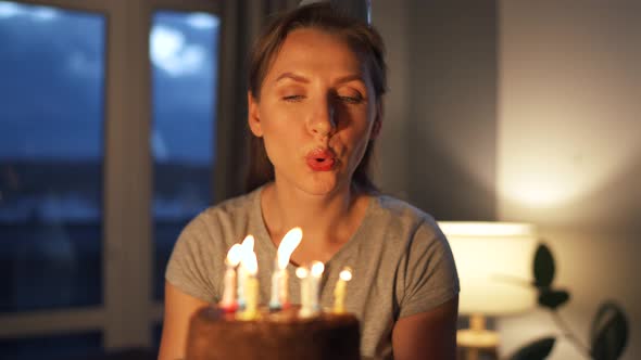 Happy Excited Woman Making Cherished Wish and Blowing Candles on Holiday Cake Celebrating Birthday