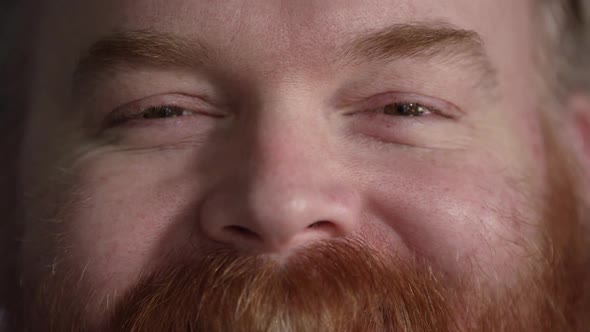 Tight shot of mans nose and eyes as he smiles