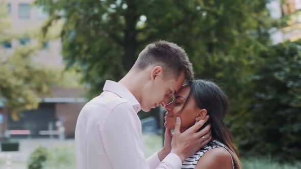 Young Mixed-race Family of Two Touching Foreheads and Hugging Outdoors