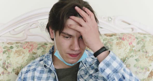 Boy with a Medical Mask Bored and Misses on a Sofa at Home During Selfisolation