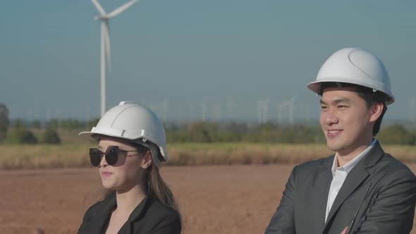 Team Asian engineers in wind turbine farm