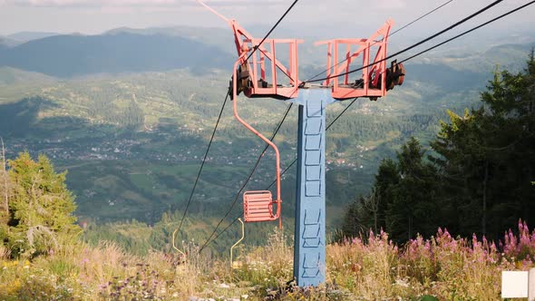 Empty mountain ski chairlift with steel cables on the top of hill