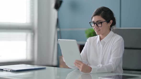 Indian Businesswoman Celebrating Success on Tablet in Office