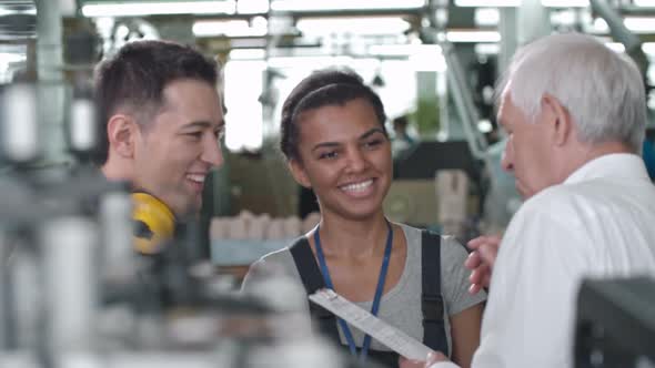 Cheerful Factory Workers Discussing Tasks