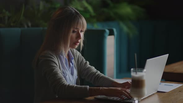 Young Asian Attractive Female Office Worker Sitting at the Laptop Computer at the Desk Working and