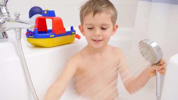 Cute Little Boy Taking Bath with Foam and Playing with Toys