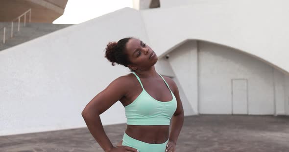 Fit african girl doing sport stretching exercise in the city