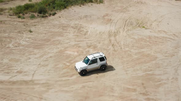 Aerial View of a Car Driving on Sand