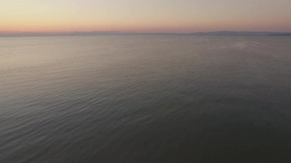 Aerial flight above the water of the sea against horizon line