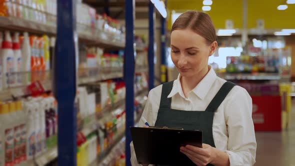 Young Store Manager Writes Products List in Department