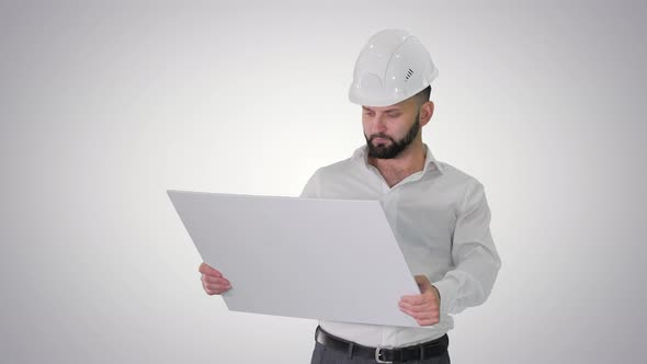 Man Engineer Walking in Helmet Looking at Project of Reconstruction on Gradient Background.