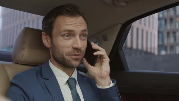Businessman Talking on Phone in Auto