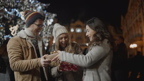 Friends Presenting Gifts to Each Other at Xmas Night in Prague