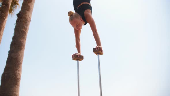 Gymnastics By the Sea  a Young Blonde Woman Doing a Handstand on the High Small Beams