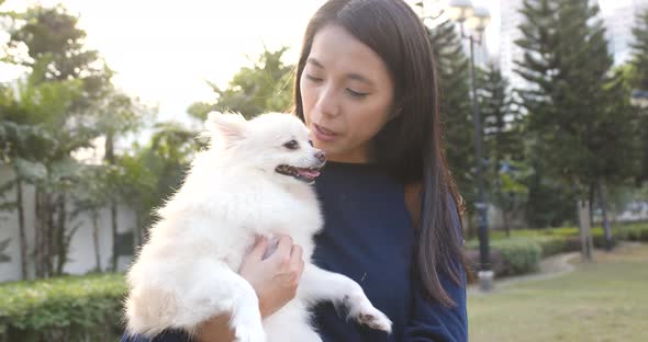 Woman with her Pomeranian dog at outdoor park