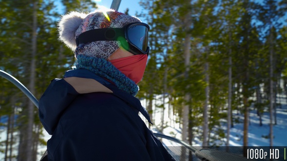 Woman Skier Looks Around On The Chair Lift To The Top Of The Mountain