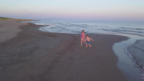 Young Sister and Brother Who Are Playing in the Sea