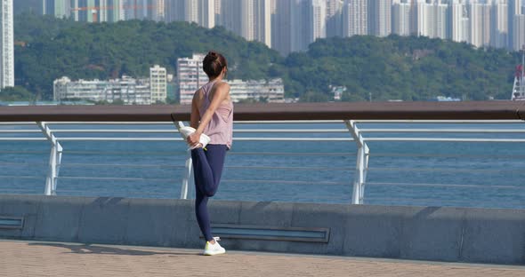 Woman stretch legs before running in the city