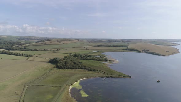 Aerial tracking from right to left above the fleet lagoon at Abbotsbury, near Chesil Beach. The swan