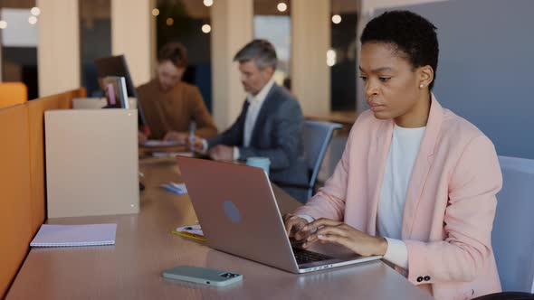 African American Young Concentrated Woman Working on the Laptop While Sitting at Office