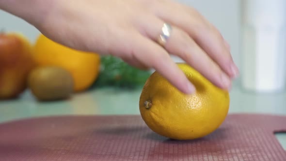 Man's hand takes away the yellow lemon from the cutting desk on gray table on white bacground with f