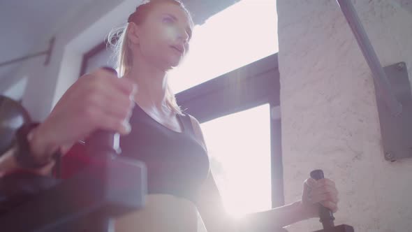 Handheld view of young woman exercising in fitness center.  Shot with RED helium camera in 8K