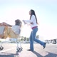 Young woman pushing the grocery cart, while her friend is sitting inside during sunset. - VideoHive Item for Sale
