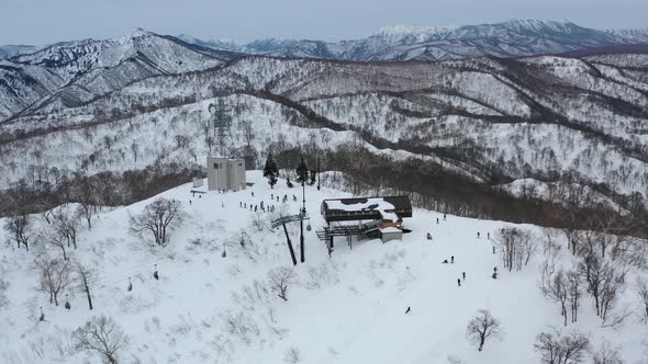 skiers on ski lift arriving at snowy mountain peak slope in winter at nozawa onsen in nagano japan