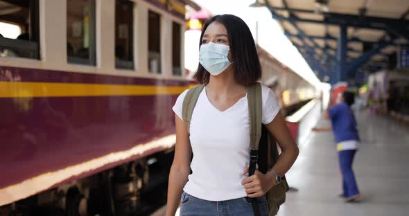 Traveler woman medical face mask and walking at train station