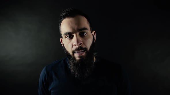 Close-up Portrait of Bearded Man Exhales Steam and Looking Right Into the Camera