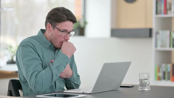 Middle Aged Man Having Coughing While Working on Laptop