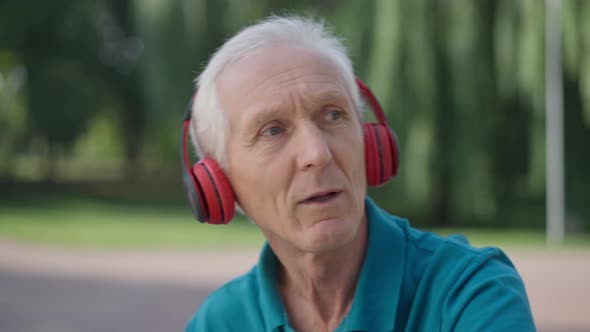 Closeup Portrait of Carefree Caucasian Senior Man Singing Dancing in Slow Motion Listening to Music