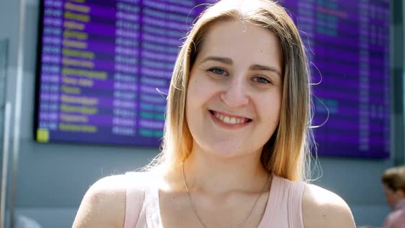 Video of Beautiful Smiling Blonde Woman Looking in Camera at International Airport Terminal