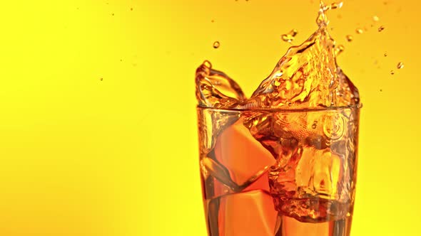 Super Slow Motion Shot of Ice Cubes Falling Into Glass of Ice Tea and Making Splash at 1000 Fps