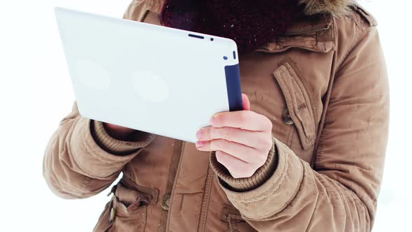 Smiling woman in fur jacket using digital tablet