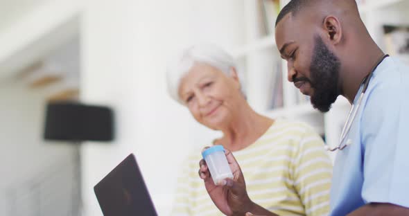 Video of hapopy african american male doctor giving medicines to caucasian senior woman