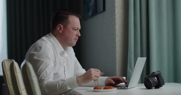 Photographer Processes Photo On Laptop And Eats Sandwich